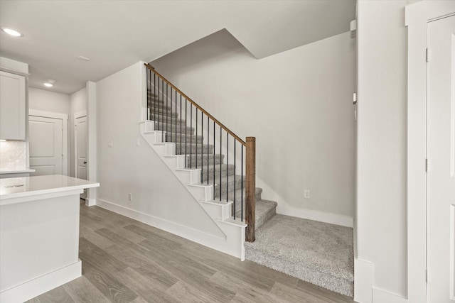 staircase with wood finished floors and baseboards