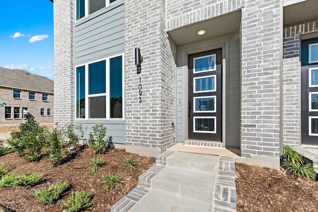 doorway to property with brick siding