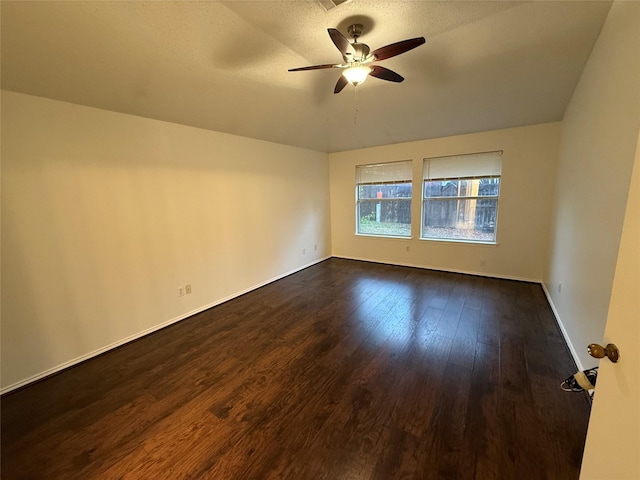 unfurnished room with baseboards, a textured ceiling, a ceiling fan, and dark wood-style flooring