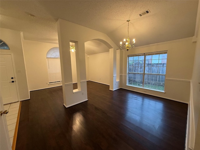 interior space with a textured ceiling, a chandelier, wood finished floors, visible vents, and vaulted ceiling