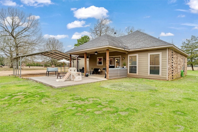 rear view of property featuring a shingled roof, a patio area, ceiling fan, and a lawn