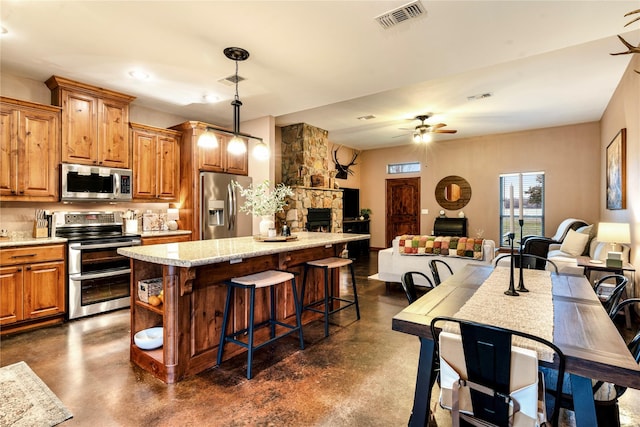 kitchen featuring open floor plan, stainless steel appliances, visible vents, and finished concrete flooring