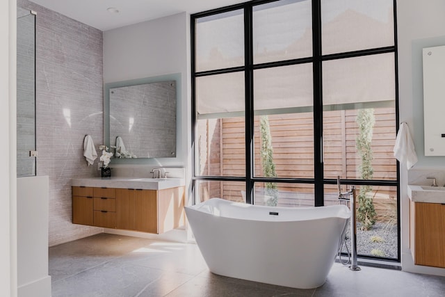 full bathroom with expansive windows, a soaking tub, and vanity