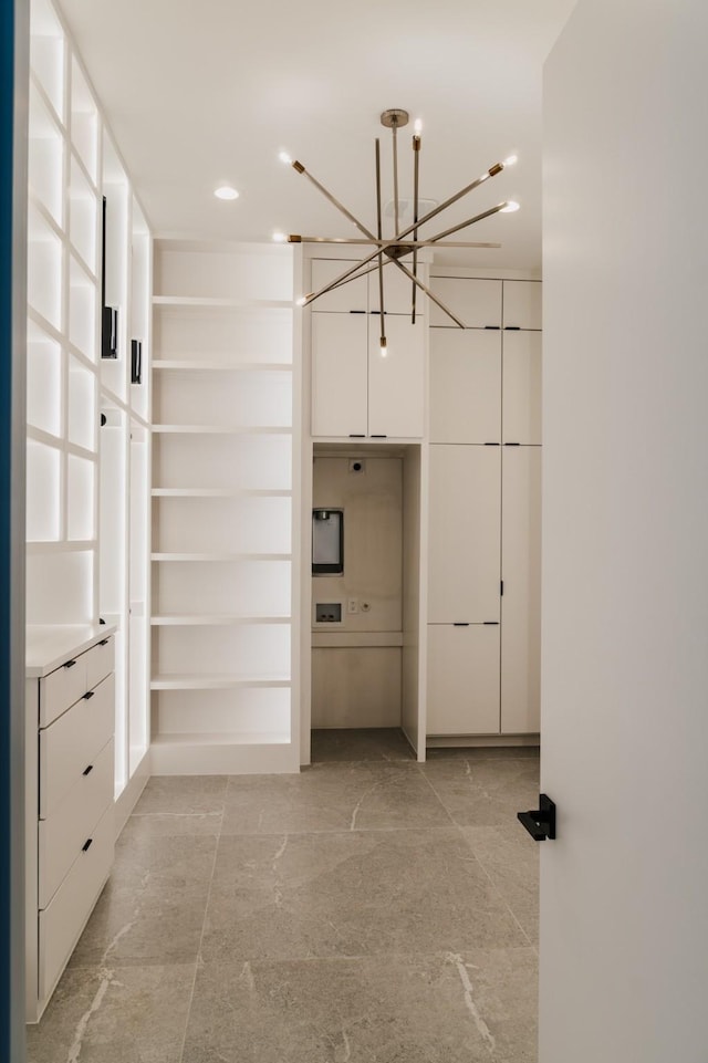 walk in closet with an inviting chandelier