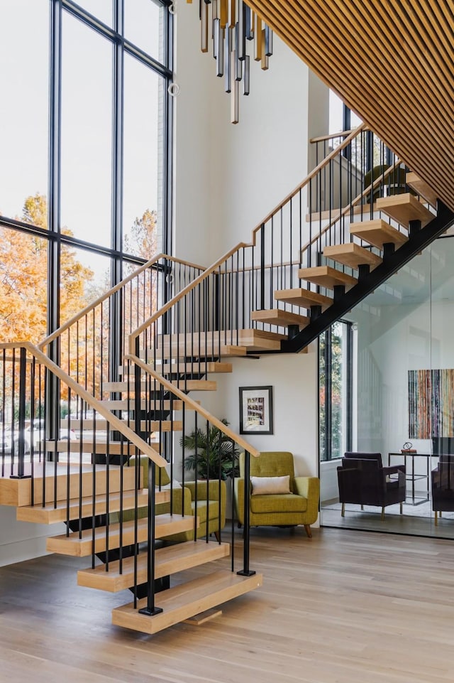 staircase with a high ceiling and wood finished floors