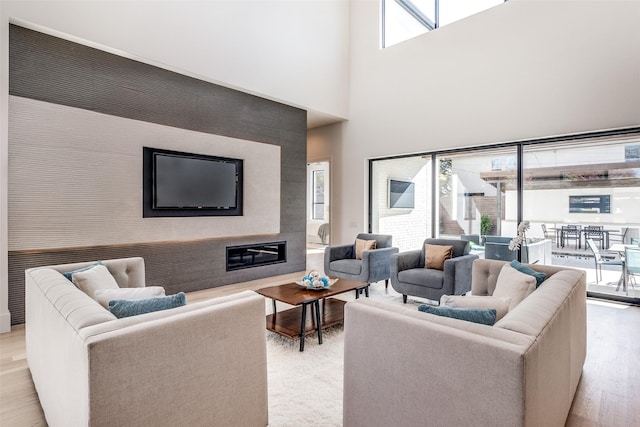 living area featuring a towering ceiling and wood finished floors