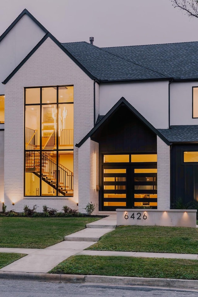 property entrance with a yard and brick siding