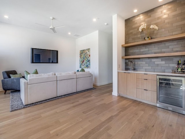 living area with wet bar, wine cooler, recessed lighting, and light wood finished floors