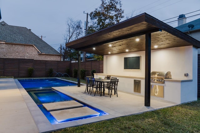 view of pool with a fenced backyard, a grill, a fenced in pool, an outdoor kitchen, and a patio area