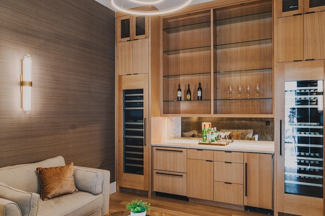 bar with wine cooler and light wood-style floors