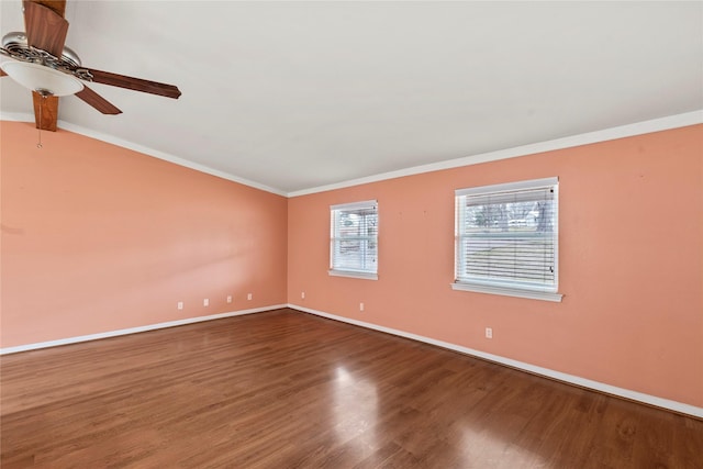 empty room featuring lofted ceiling, wood finished floors, a ceiling fan, baseboards, and crown molding