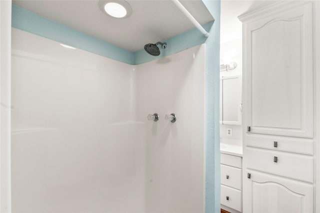 bathroom featuring walk in shower and vanity