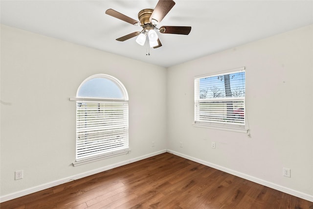 spare room featuring wood finished floors, a ceiling fan, and baseboards