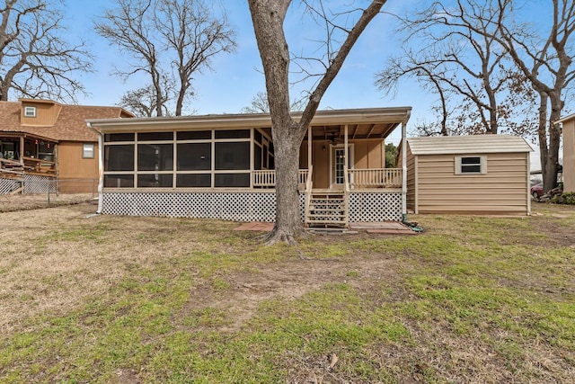 back of property featuring an outbuilding, a yard, a storage shed, a sunroom, and fence