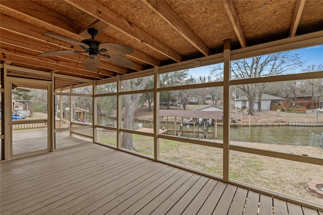 unfurnished sunroom featuring a water view, a residential view, and a ceiling fan