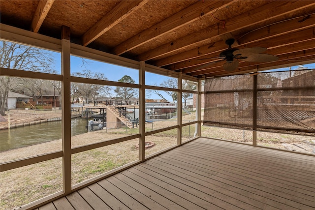 unfurnished sunroom featuring a water view and a ceiling fan