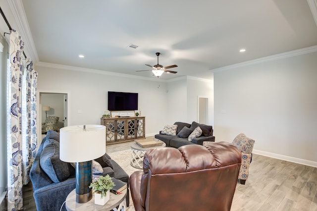 living room with baseboards, light wood finished floors, visible vents, and crown molding