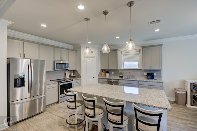 kitchen featuring appliances with stainless steel finishes, light wood-style flooring, gray cabinets, and visible vents