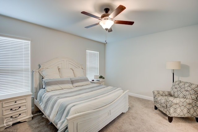 bedroom featuring light carpet, ceiling fan, and baseboards