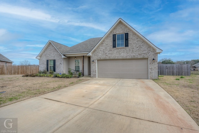 traditional-style home with a front yard, fence, concrete driveway, and brick siding