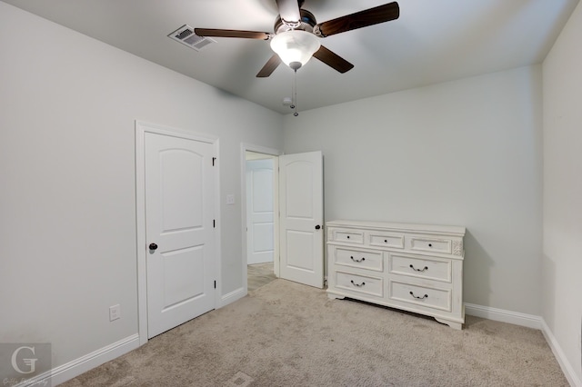 unfurnished bedroom featuring light colored carpet, visible vents, ceiling fan, and baseboards