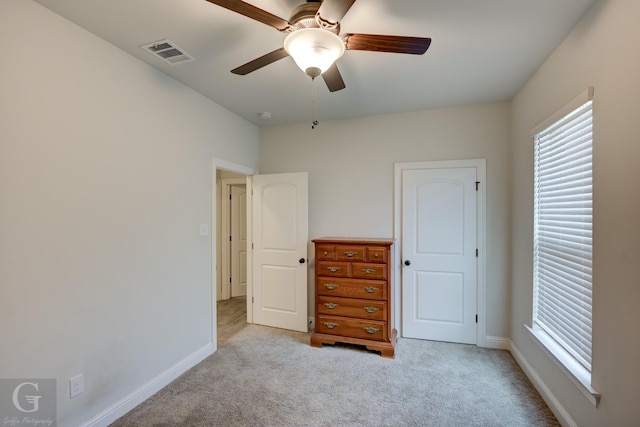 unfurnished bedroom with a ceiling fan, baseboards, visible vents, and carpet flooring