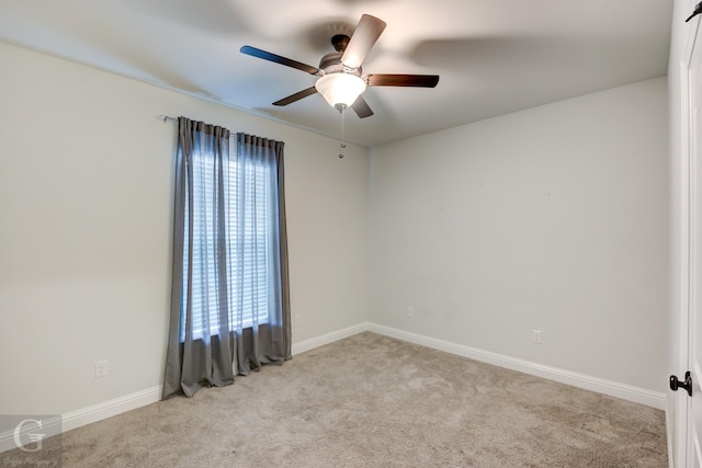 unfurnished room with a ceiling fan, light colored carpet, and baseboards