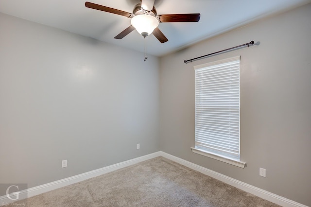 empty room featuring ceiling fan, carpet floors, and baseboards