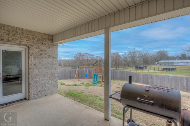 view of patio with a fenced backyard, a playground, and area for grilling