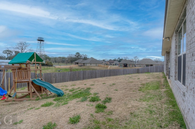 view of yard featuring a playground and fence