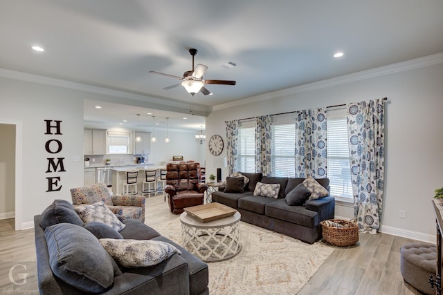 living room with ornamental molding, light wood-type flooring, and visible vents