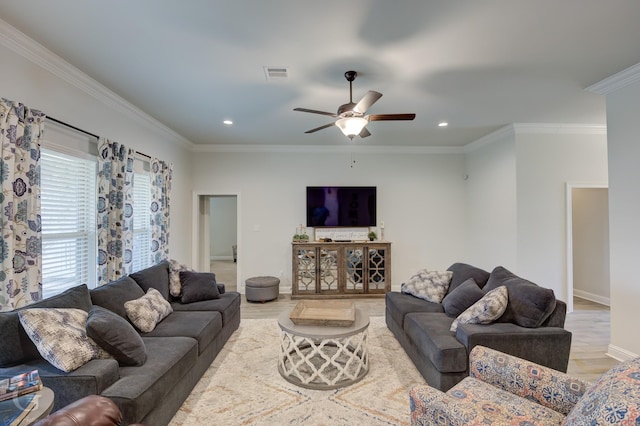 living room featuring ceiling fan, visible vents, wood finished floors, and ornamental molding