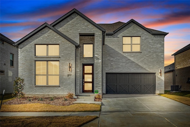 view of front of house featuring a garage, brick siding, and driveway