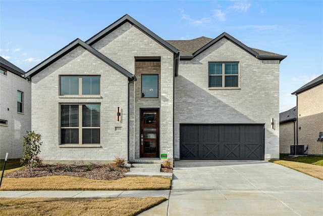 view of front facade featuring a garage, driveway, and brick siding