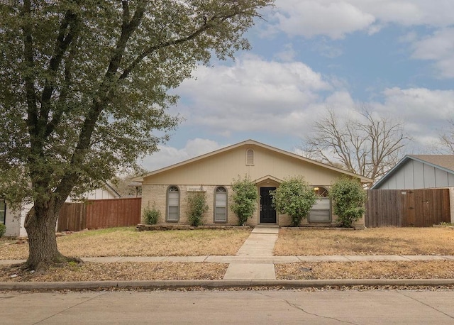 view of front of property featuring brick siding and fence