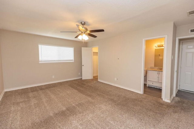 unfurnished bedroom with carpet floors, a spacious closet, visible vents, and baseboards