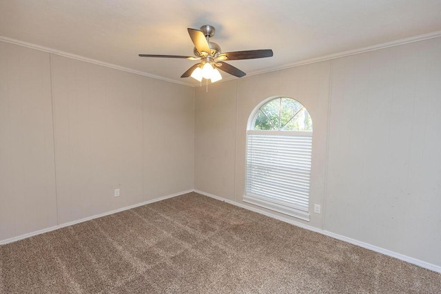 carpeted spare room with ornamental molding and a ceiling fan