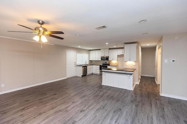 kitchen featuring dark countertops, dark wood-style floors, visible vents, and stainless steel appliances