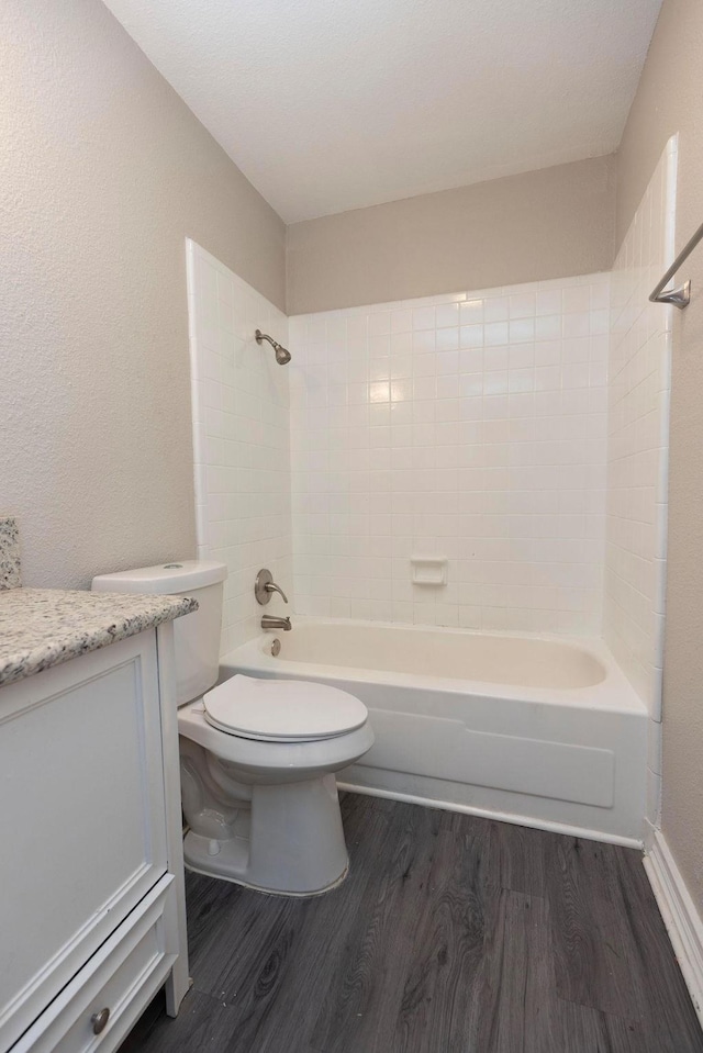 full bathroom with toilet, tub / shower combination, wood finished floors, and vanity