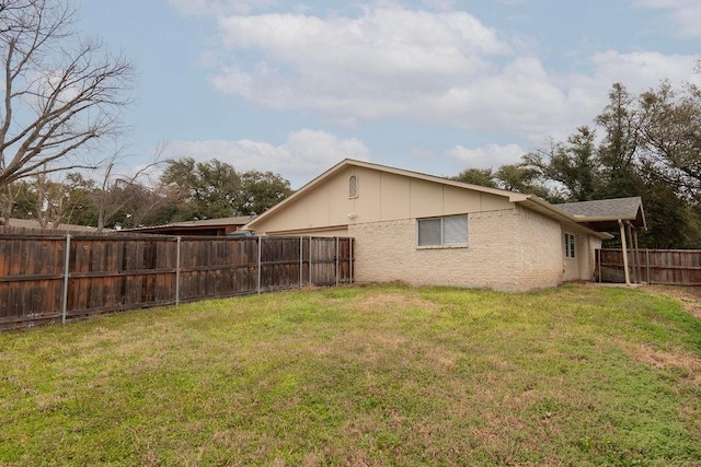 exterior space with a fenced backyard and a lawn