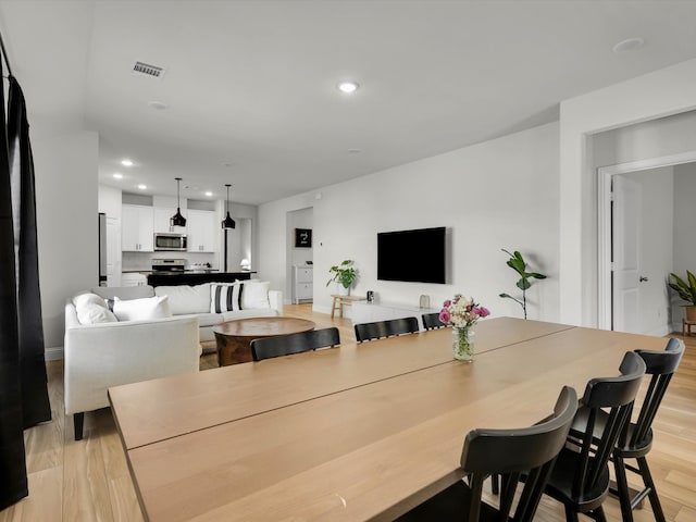 dining space featuring light wood finished floors, visible vents, and recessed lighting