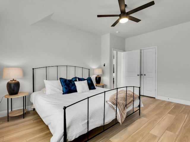 bedroom featuring light wood-style floors, a closet, ceiling fan, and baseboards