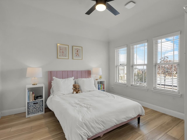 bedroom with light wood-style floors, baseboards, and a ceiling fan