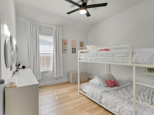 bedroom with lofted ceiling, ceiling fan, baseboards, and light wood-style floors