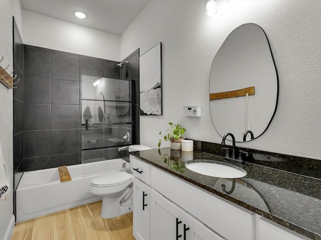 bathroom featuring toilet, shower / tub combination, wood finished floors, and vanity