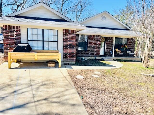 single story home with a garage, concrete driveway, and brick siding