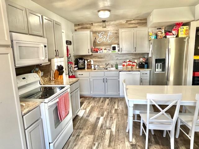 kitchen with white appliances, light countertops, a sink, and decorative backsplash