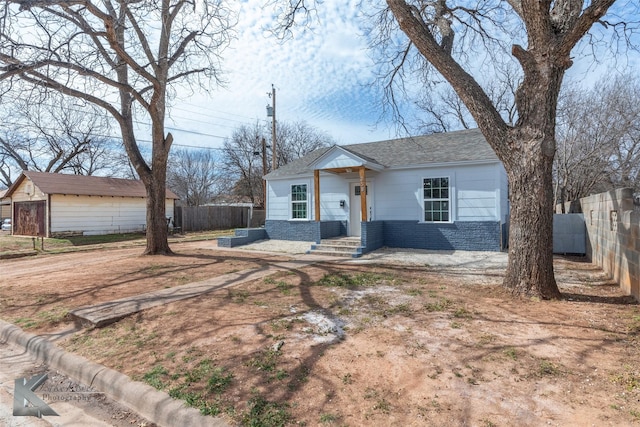 view of front of house with brick siding and fence