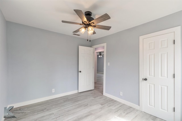 empty room with visible vents, ceiling fan, light wood-style flooring, and baseboards