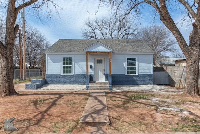 view of front of house with a shingled roof and fence